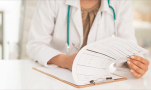 doctor writing on clipboard