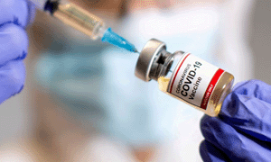 syringe going into covid vaccine bottle